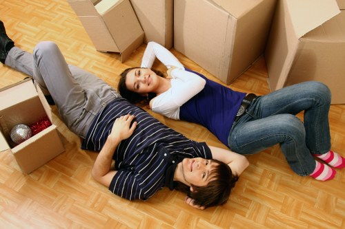 Professional movers carrying furniture down stairs in a Lambeth flat